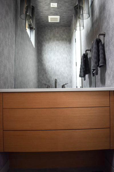 Interior design of wood vanity in bathroom with grey fun wallpaper. Designed by interior designer Erica LeMaster Sargent. 