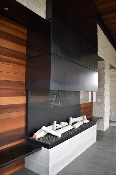 Interior design of custom exposed gas fire place with wood accent wall. Designed by interior designer Erica LeMaster Sargent. 