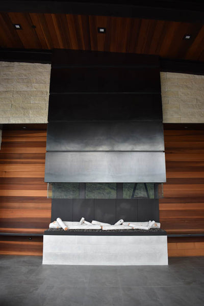 Interior design of custom black fireplace with wood accents. Designed by interior designer Erica LeMaster Sargent. 