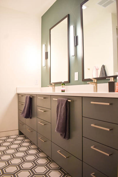 Interior design of bathroom with dark cabinets with gold hardware and green accent wall. Designed by interior designer Erica LeMaster Sargent. 