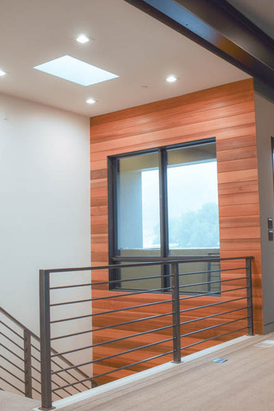 terior design of staircase with horizontal metal railing and wood accent wall. Designed by interior designer Erica LeMaster Sargent. 