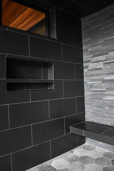 Interior design of black shower area with built in bench seat. Designed by interior designer Erica LeMaster Sargent. 