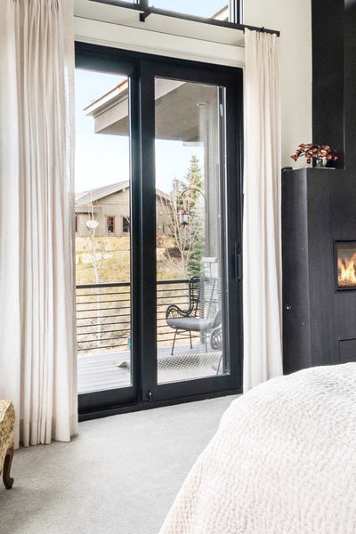 Interior design of master bedroom with balcony and custom fireplace. Designed by interior designer Erica LeMaster Sargent. 