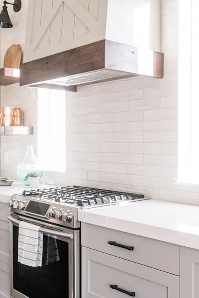 Interior design of kitchen with quartz countertops and stainless steal gas range. Designed by interior designer Erica LeMaster Sargent. 