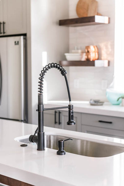 Interior design of kitchen with sink on island with quartz countertops. Designed by interior designer Erica LeMaster Sargent. 