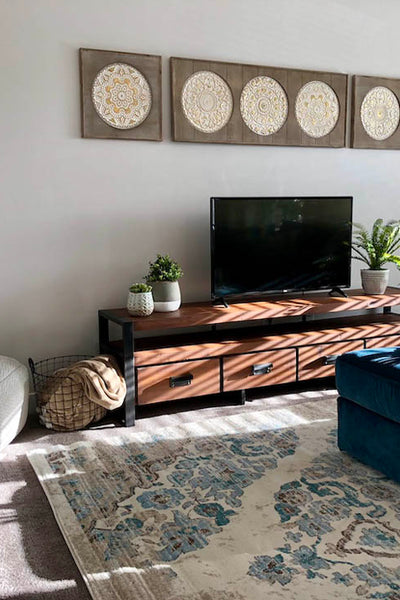 Interior design of living area with wood media stand and boho decor. Designed by interior designer Erica LeMaster Sargent. 