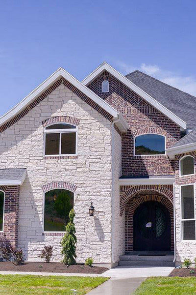 Exterior design of Texas colonial styled home with red brick and cream stone. Designed by interior designer Erica LeMaster Sargent. 